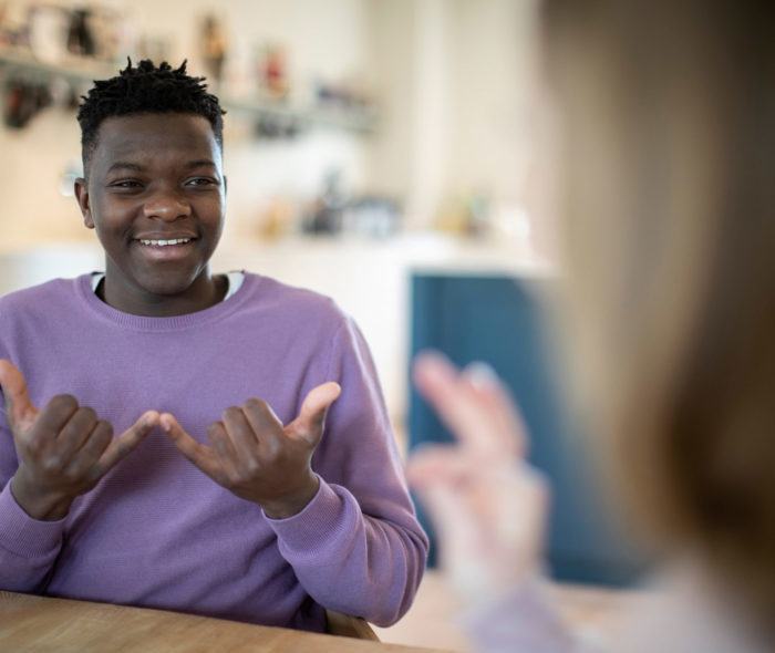 Teenage Boy And Girl Having Conversation Using Sign Language