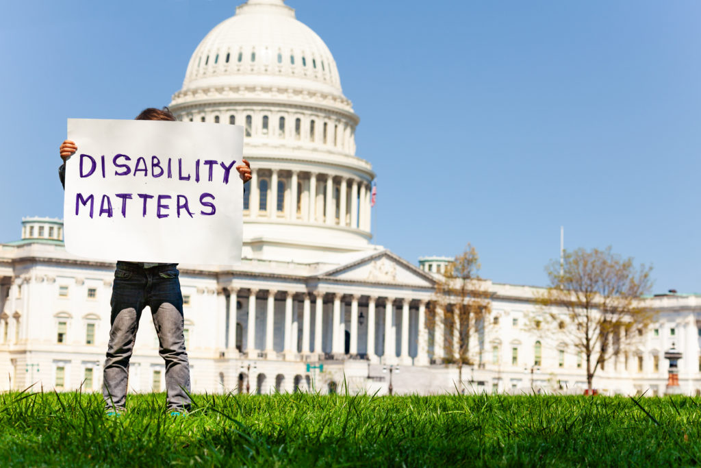 Child boy protest in front of the USA capitol in Washington holding sign saying disability matters
